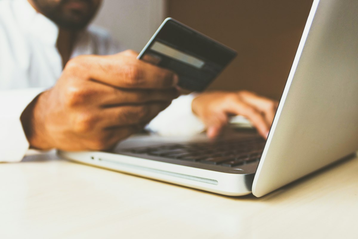 Person paying by card on a laptop