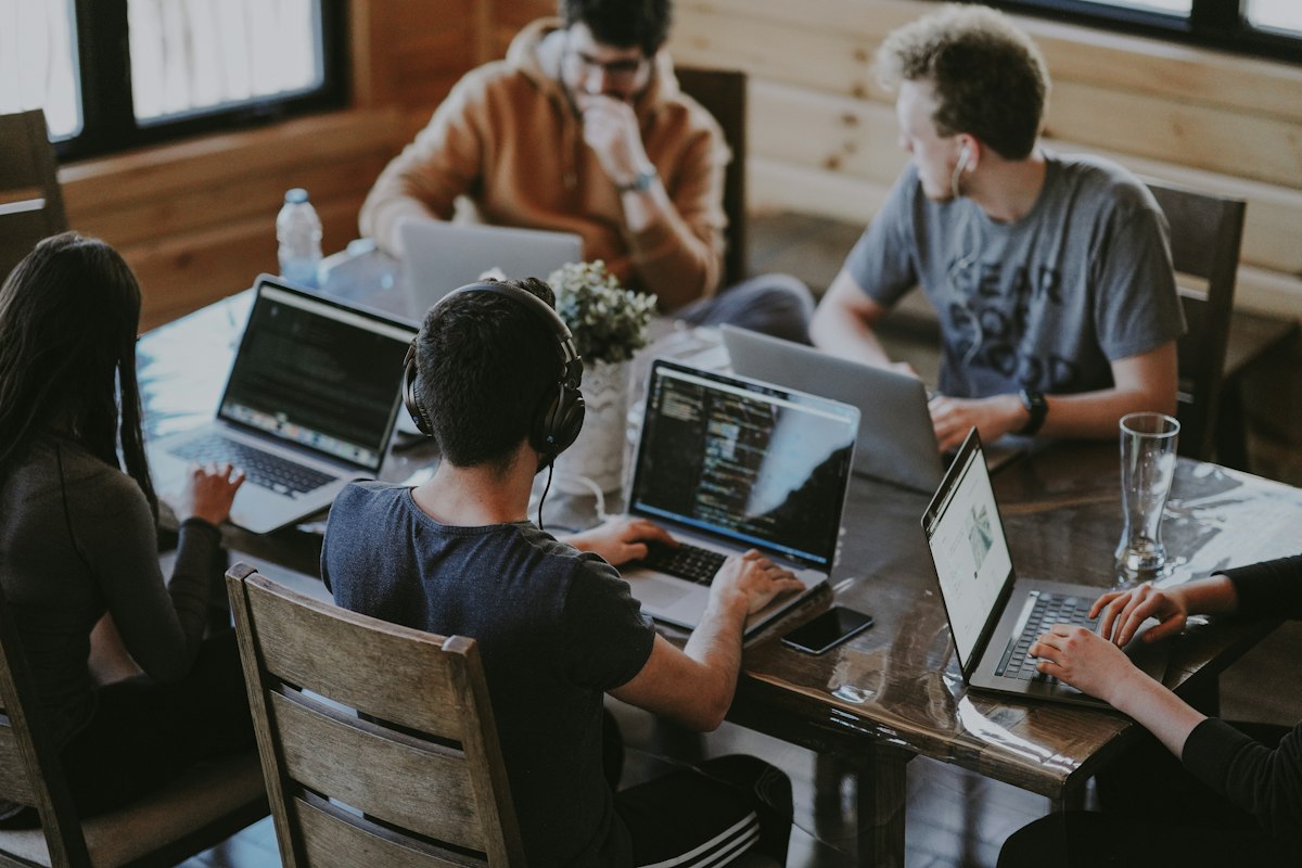 A small team collaborating around laptops